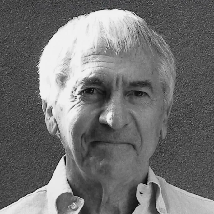 Retrato em preto e branco de Jorge Frascara, homem idoso de cabelos brancos, olhando para a câmera.